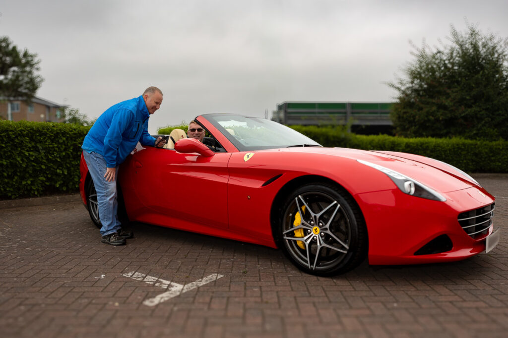 Director of Complexus talking with a client in his Ferrari with a tracking device and immobiliser