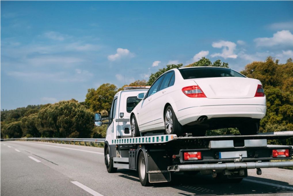 flatbed truck carrying car asset along the motorway