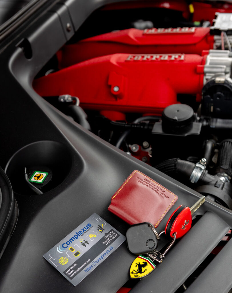 Ferrari engine and Ferrari key chain with a driver identification token and Complexus business card